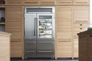 Refrigerador de acero inoxidable de la serie Pro Sub-Zero en una cocina con gabinetes de madera ligera