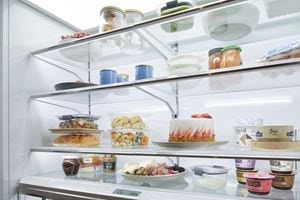 Refrigerador de la serie Classic Sub-Zero de tamaño completo con puerta francesa de 48 pulgadas con cuatro niveles de estanterías de alimentos frescos relucientes.